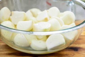 salting onions for onion kimchi in a Pyrex bowl