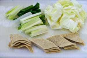 cutting fish cake sheets and vegetables on a cutting board