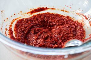 Making onion kimchi seasonings in a large Pyrex bowl