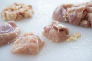 cutting chicken thigh into bite size pieces