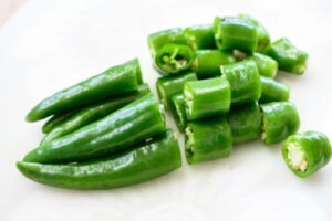 Cutting Korean chili peppers into 1 inch pieces on a cutting board
