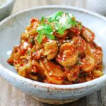 Red spicy seasoned Korean pickle slices in a small bowl
