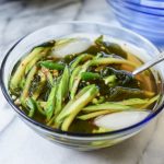 Korean chilled cucumber soup in a glass bowl with a spoon
