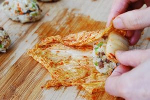 Rolling rice balls in a kimchi leaf